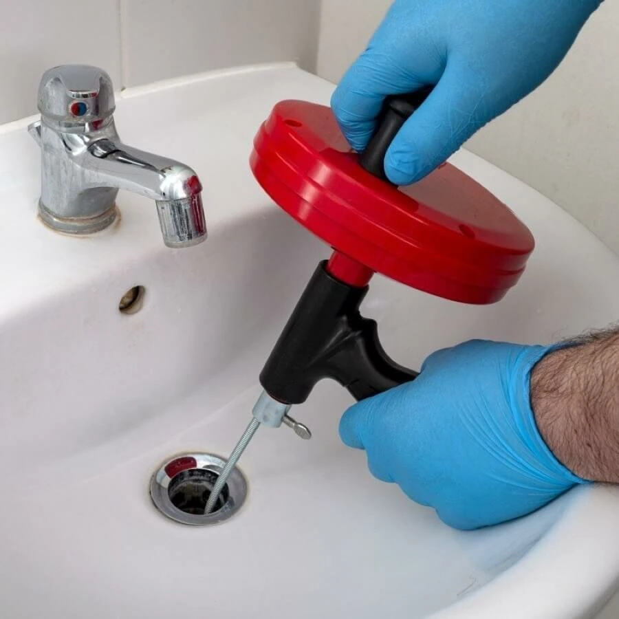 technician snaking a bathroom drain